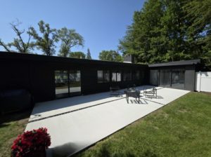 Modern black house with concrete patio and outdoor seating area
