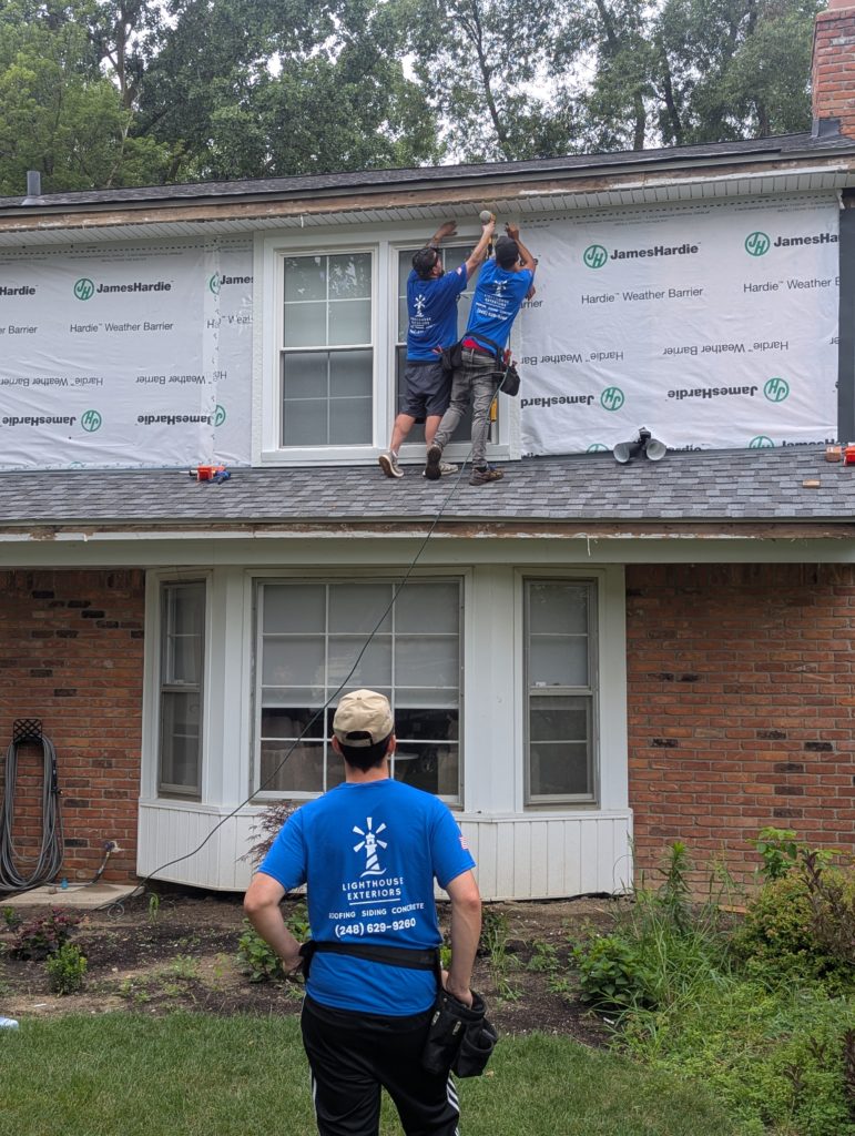Picture of the Lighthouse Exteriors team installing siding on a home